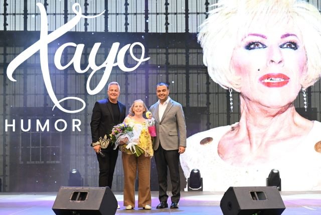 El alcalde Pedro Rodríguez junto a Roberto Herrera entrega un presente a Paca Moreno hermana de Xayo en el transcurso del Festival