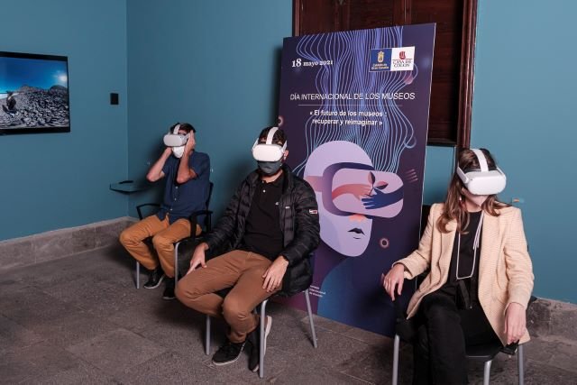 Tres personas con gafas virtuales disfrutan de una visita guiada por la Casa de Colón